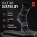 Black and gray 5-inch crew height trail running sock displayed on rock, showing compression zones and support features